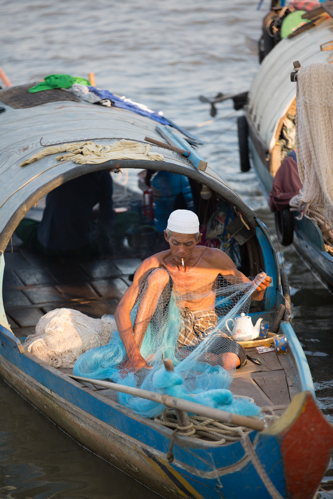 Cham man repairing fishing nets Phnom Penh